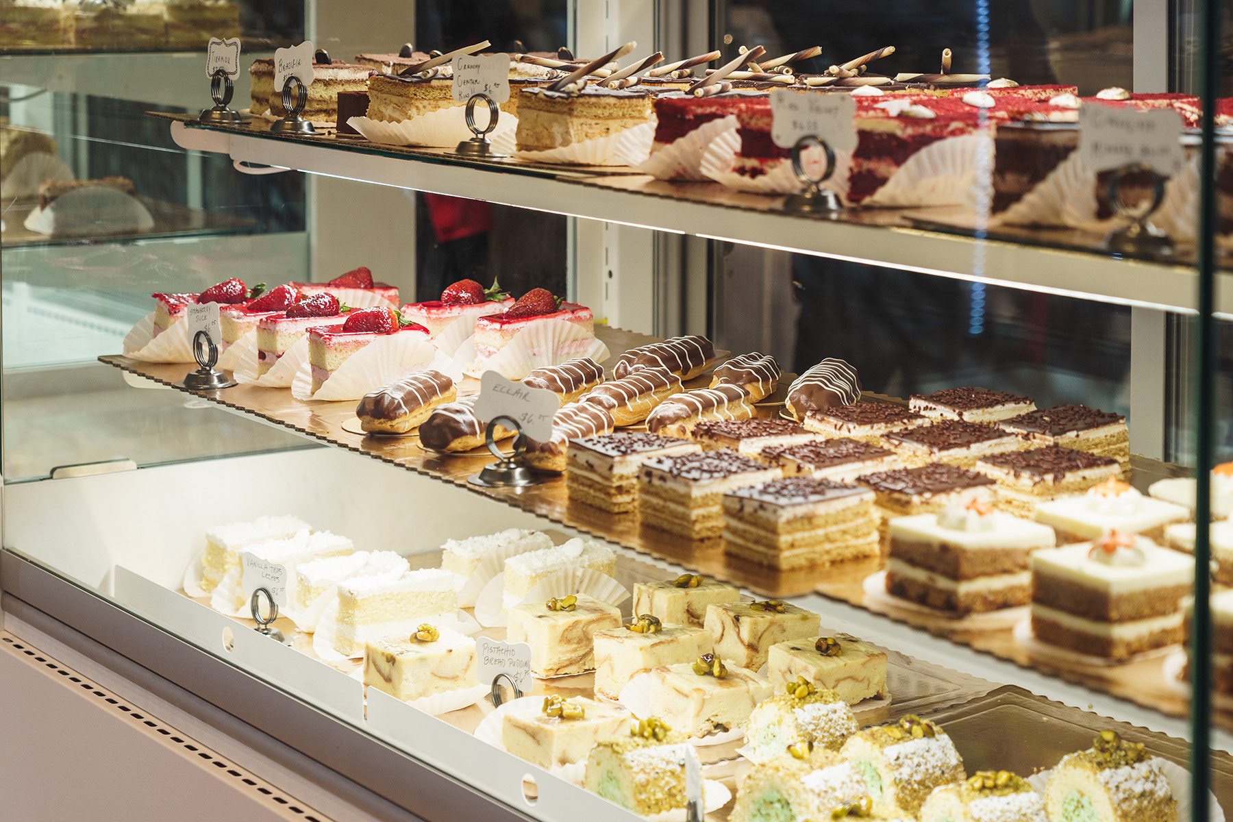 A display case filled with various types of cakes and pastries.